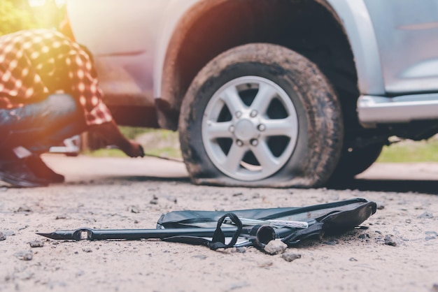Mecánico reparando un pinchazo de coche en la carretera