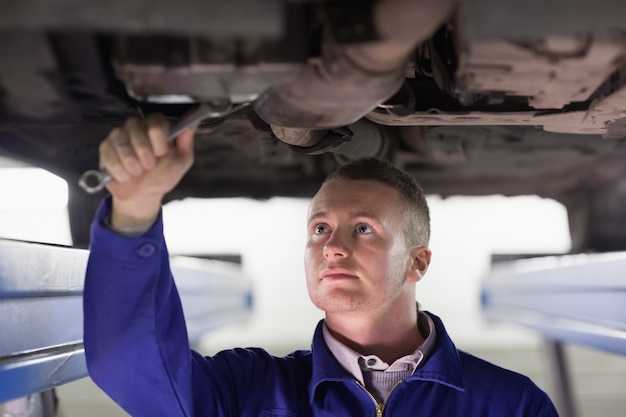 Mecánico de reparar un automóvil con una llave