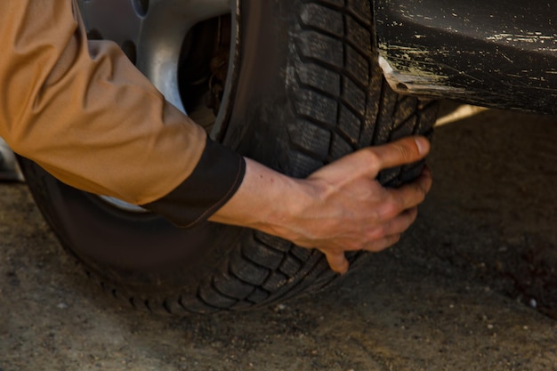 Un mecánico retira un neumático de automóvil Un hombre que trabaja en una máquina para quitar el caucho de un disco de rueda