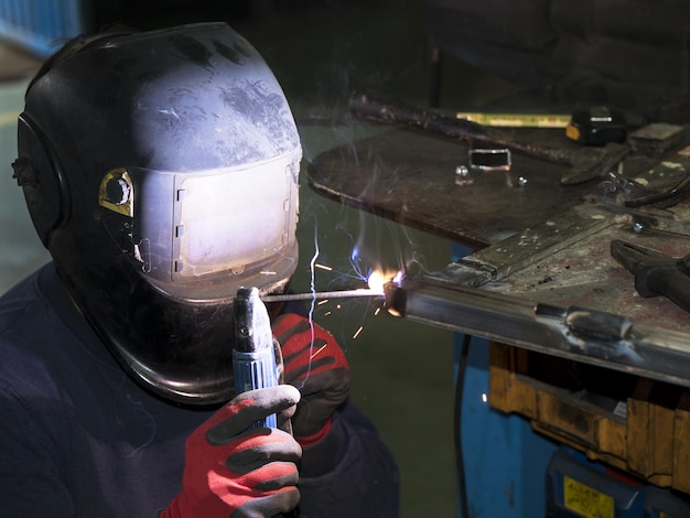 Mecánico soldador fabricando una puerta de metal