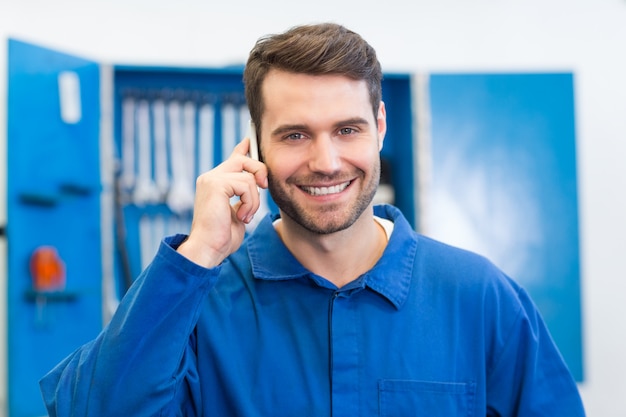 Mecânico sorridente no telefone