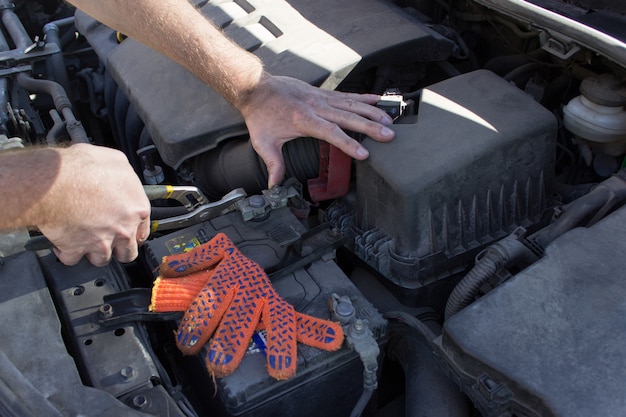 Mecánico en el trabajo, Cerrar detalles del motor del automóvil bajo el capó abierto.