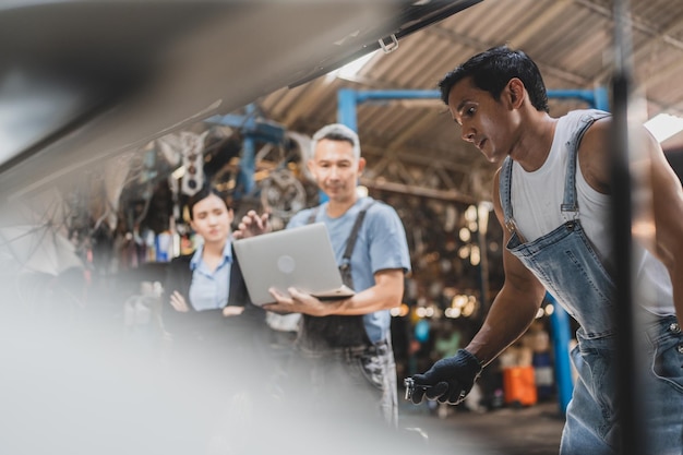 Mecânico trabalhando e verificando sobre técnico de inspeção de serviço de motor de carro automático com trabalho automotivo para manutenção ou reparo de automóvel em motor de carro industrial de negócios de garagem de motor