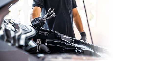 Mecánico usando la llave inglesa para reparar el problema del motor del coche