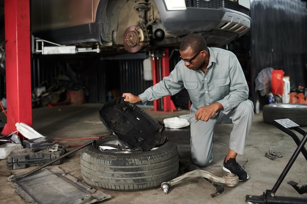 Mecânico verificando a tampa do motor do carro ao trabalhar na garagem