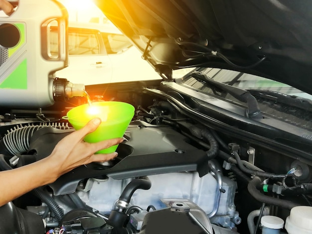 Foto mecánico vierte aceite de motor en el concepto de negocio de taller de reparación de automóviles de motor listo