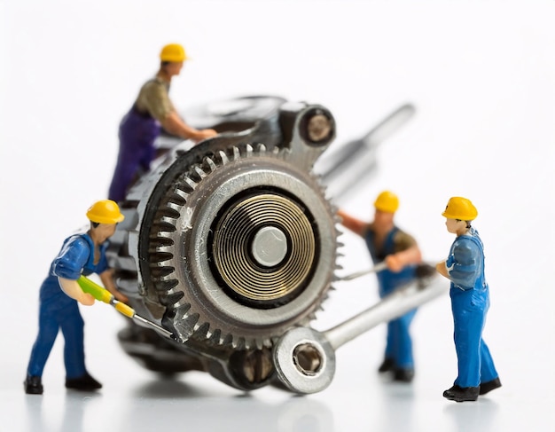 Mecânicos em miniatura reparando engrenagens
