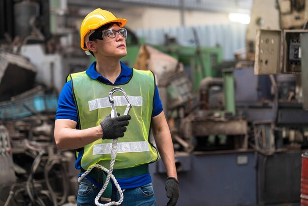 Mecánicos industriales están sosteniendo ganchos de eslingas en una planta industrial