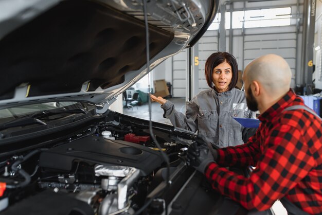 Foto mecánicos masculinos y femeninos trabajando en coche