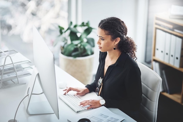 Mecanografía corporativa y una mujer con un correo electrónico en una investigación informática o trabajo de secretaria Escritorio analítico y una recepcionista con una pc en una oficina para conectividad de comunicación y trabajo