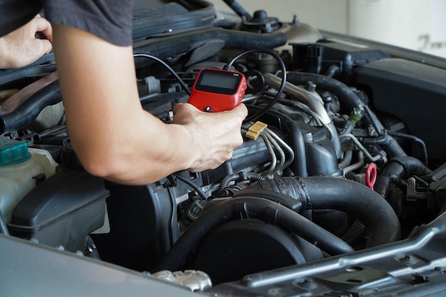 Mechanic está utilizando un lector de código de diagnóstico de coche