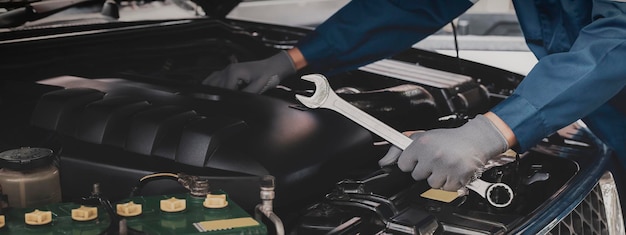 Mechaniker arbeitet am Motor des Autos in der Garage, Autoreparaturservice.