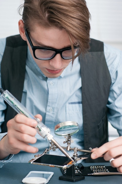 Mechaniker arbeitet intensiv mit dem Handy.