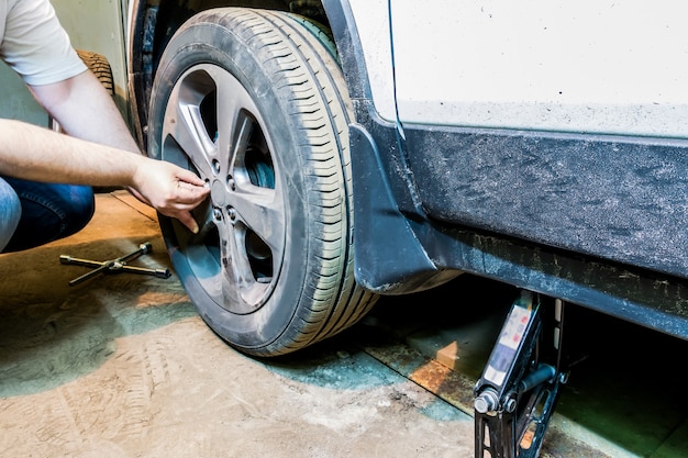 Mechaniker, der das Autorad in der Garage ändert Mann, der Reifen austauscht. Reifenservice. Reifenmontage.