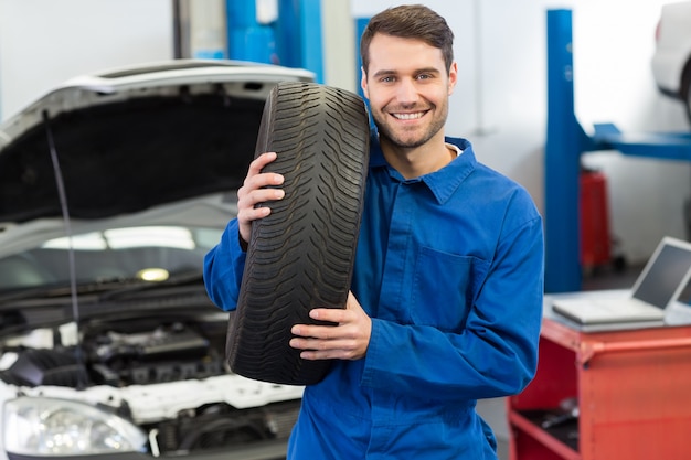 Mechaniker, der ein Reifenrad hält