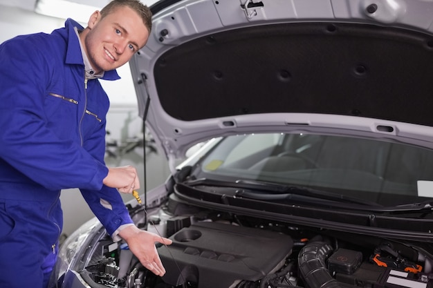 Mechaniker, der eine Maschine mit seiner Hand zeigt