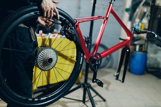 Mechaniker, der in der Werkstatt ein benutzerdefiniertes Fahrrad mit Kettenradgetriebe zusammenbaut