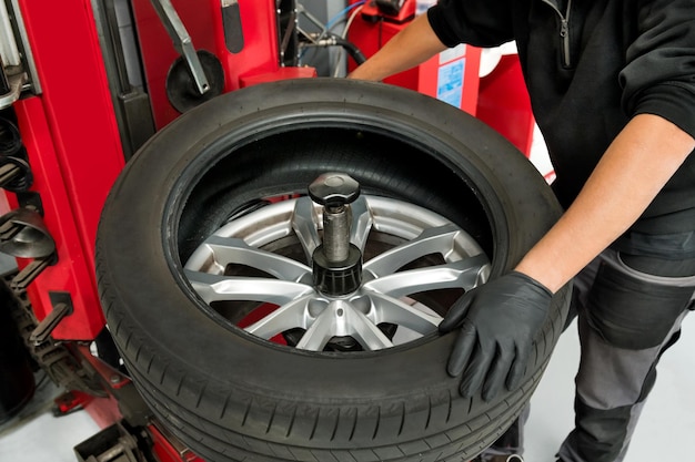 Mechaniker entfernt Reifen vom Rad in der Werkstatt