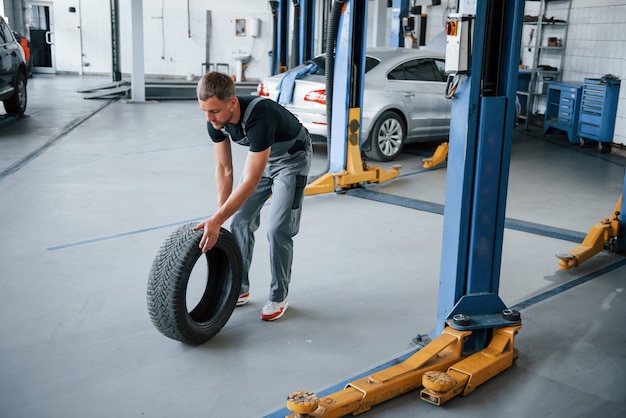 Mechaniker hält einen Reifen in der Reparaturwerkstatt