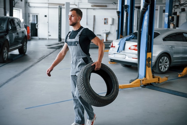 Mechaniker hält einen Reifen in der Reparaturwerkstatt