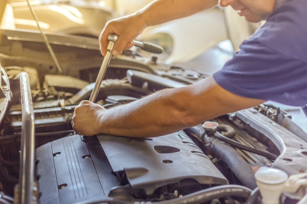 Mechaniker Hände überprüfen die Gebrauchstauglichkeit des Autos in offener Motorhaube