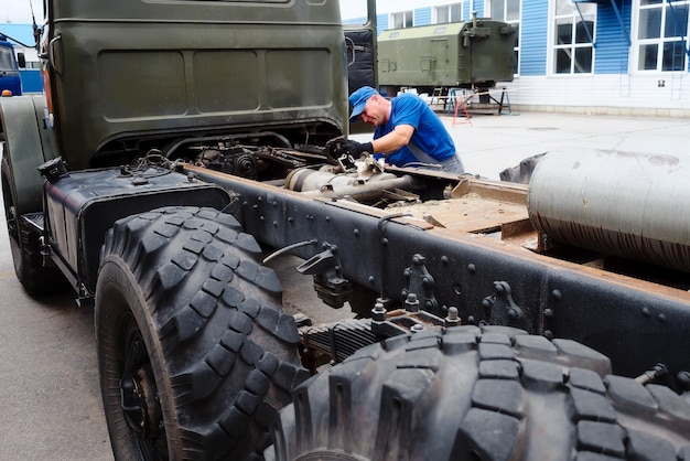 Mechaniker im Overall repariert LKW an Sommertagen draußen Dringende Reparatur von LKWs Authentischer Arbeitsablauf