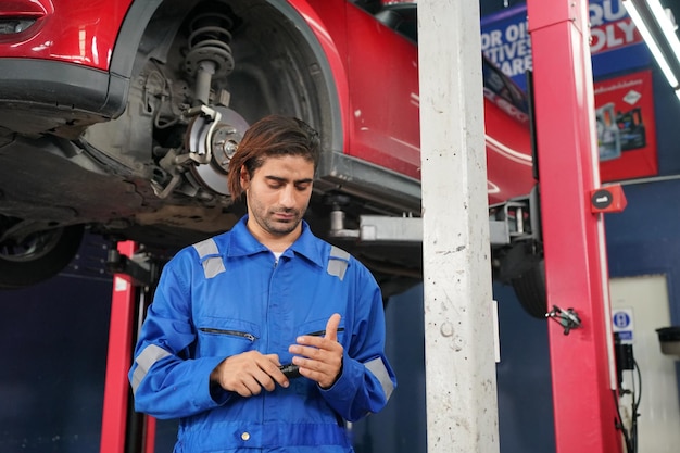 Mechaniker in blauen Overalls prüft die Gebrauchstauglichkeit des Automotors