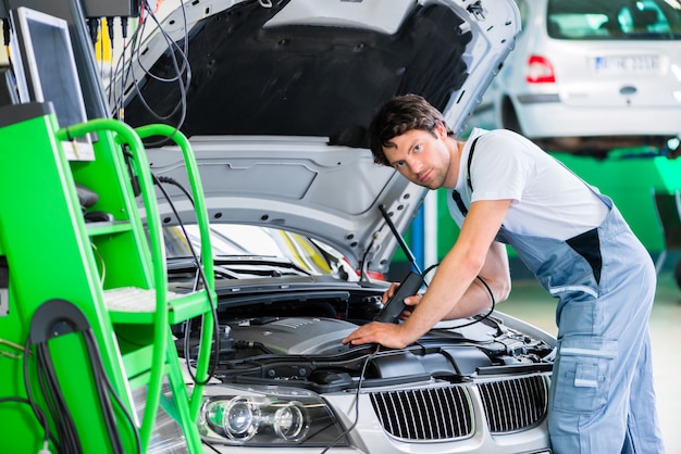 Mechaniker mit Diagnosewerkzeug in der Autowerkstatt