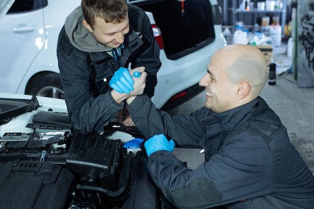 Mechaniker mit Schraubenschlüssel, die Auto in der Werkstatt reparieren.