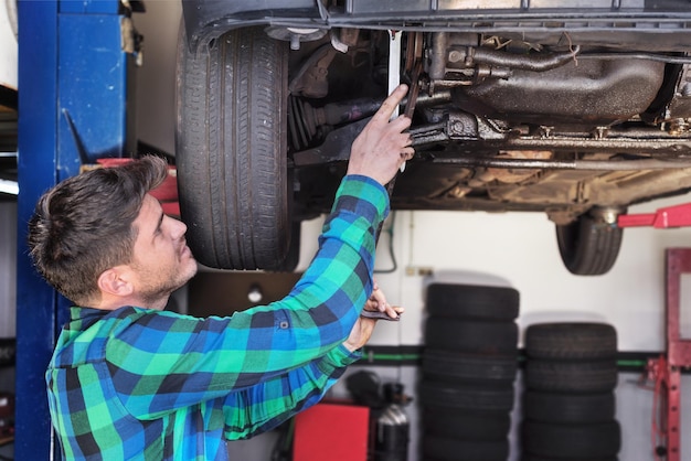 Foto mechaniker repariert ein auto in einer autoreparaturwerkstatt