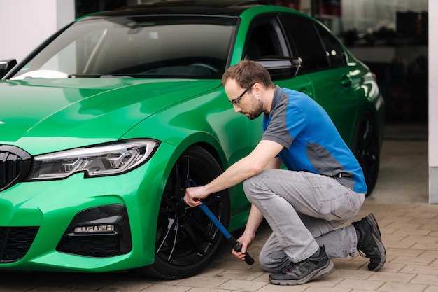 Mechaniker überprüft den Reifenservice über das Versicherungssystem in der Werkstatt. Sicherheitsfahrzeug-Radprüfung