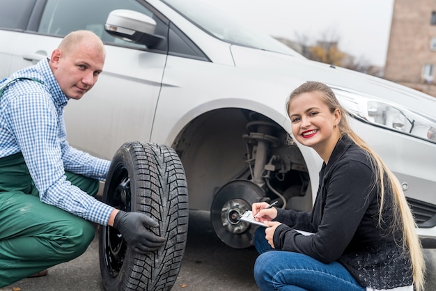 Mechaniker und Fahrer betrachten Reserverad