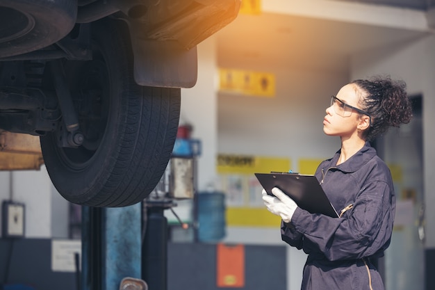 Mechaniker untersucht Unterseite beim Autoservice, Autowerkstatt.