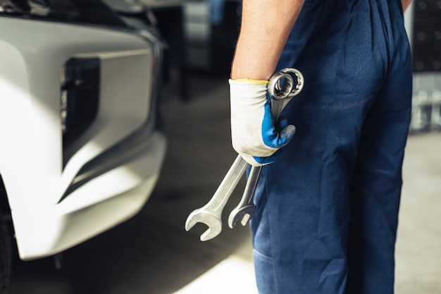 Foto mechanikerangestellter des hohen winkels mit schlüssel