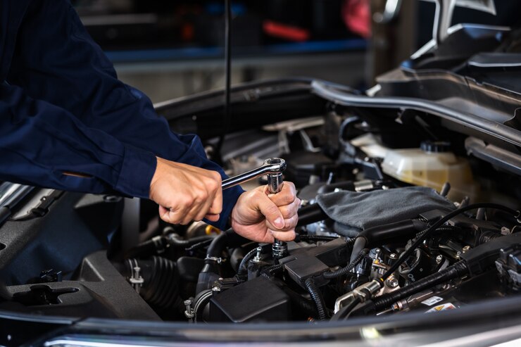 Foto mechanikerhand mit schraubenschlüssel zur reparatur des motors, autoservice