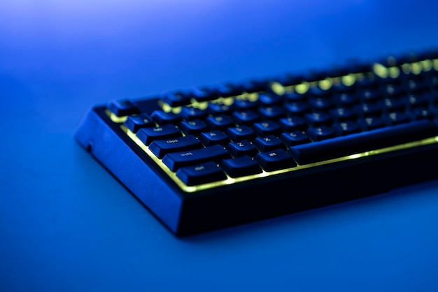 Mechanische Gaming-Computertastatur mit rgb-LED-Hintergrundbeleuchtung auf dem Tisch bei Nacht