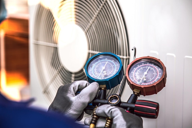 Mechanischer Techniker für Klimaanlagen, der Kältemittel mit verschiedenen Messgeräten überprüft