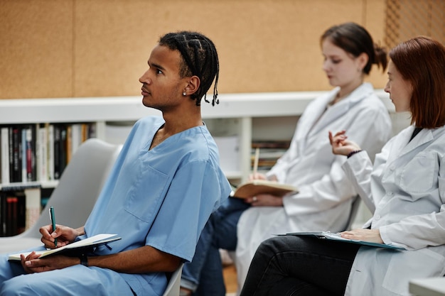 Med-Studenten sitzen während der Vorlesung oder des Seminars im Publikum in Reihe