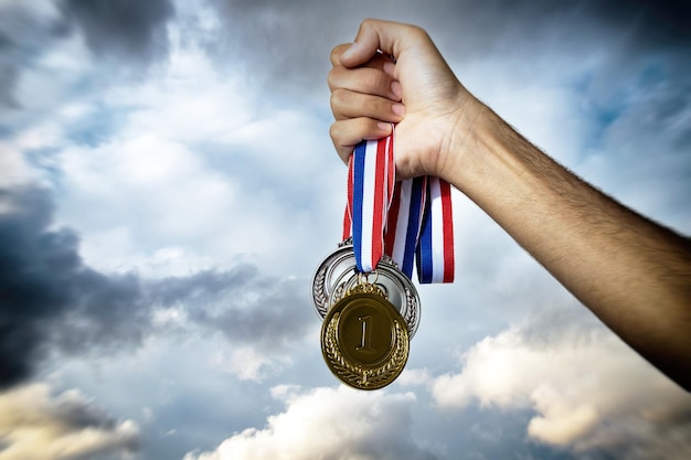 Medaillen Gold, Silber und Bronze im Himmelshintergrund der Gewinner Hand Sport Champion Athlet Siegkonzept