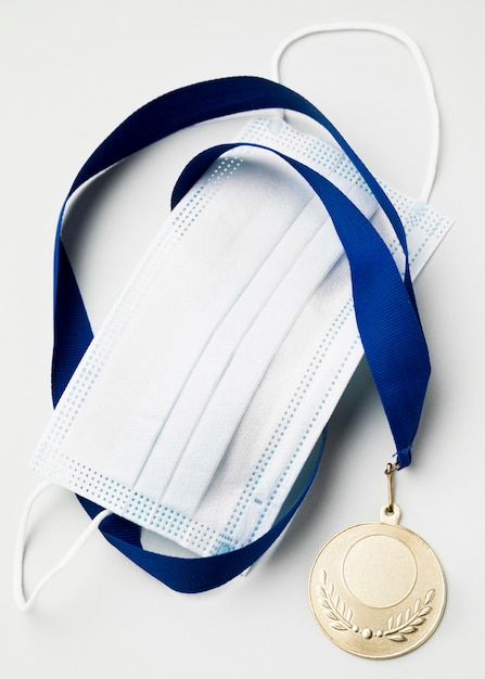 Medalha de esporte ao lado de máscara médica