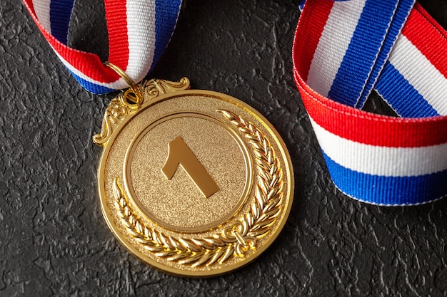 Foto medalha de ouro com fitas prêmio ao primeiro lugar na competição prêmio ao campeão