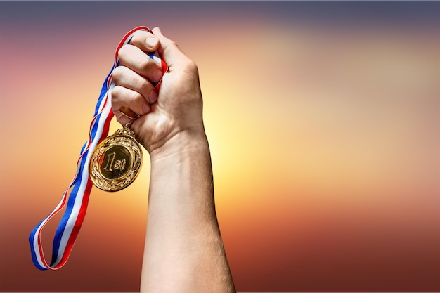 Medalla de oro con cinta en la mano en el fondo