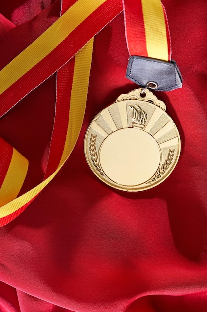 Foto medalla de oro sobre fondo rojo.