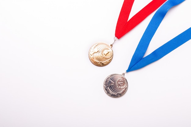 Medallas de oro y plata con cinta sobre fondo blanco.