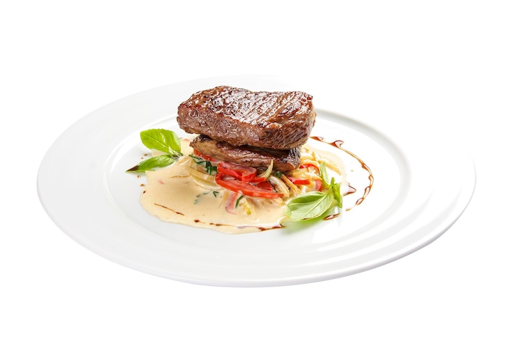 Foto medallón de ternera con verduras sobre fondo blanco
