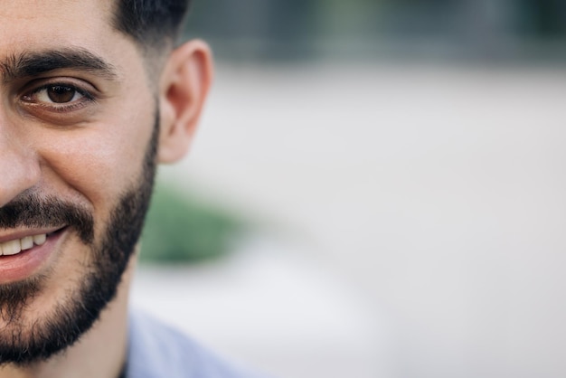 Foto media cara de hombre barbudo con ojos marrones mientras está de pie al aire libre retrato de hombre mirando a la cámara