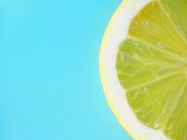 Foto media rodaja de limón amarillo sobre un fondo azul