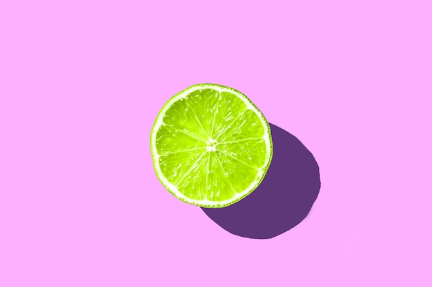Foto media rodaja de limón verde fresco sobre fondo de color