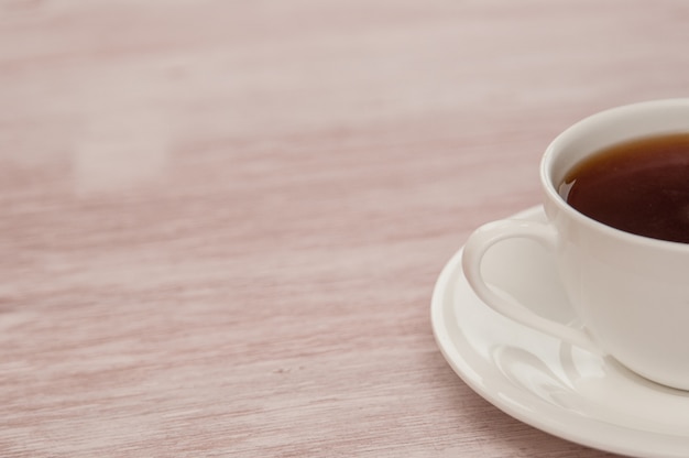 Media taza de té en una mesa de madera antigua ligera