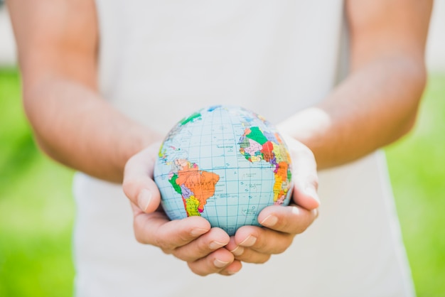 Foto mediados de sección del hombre que sostiene el pequeño globo en la mano